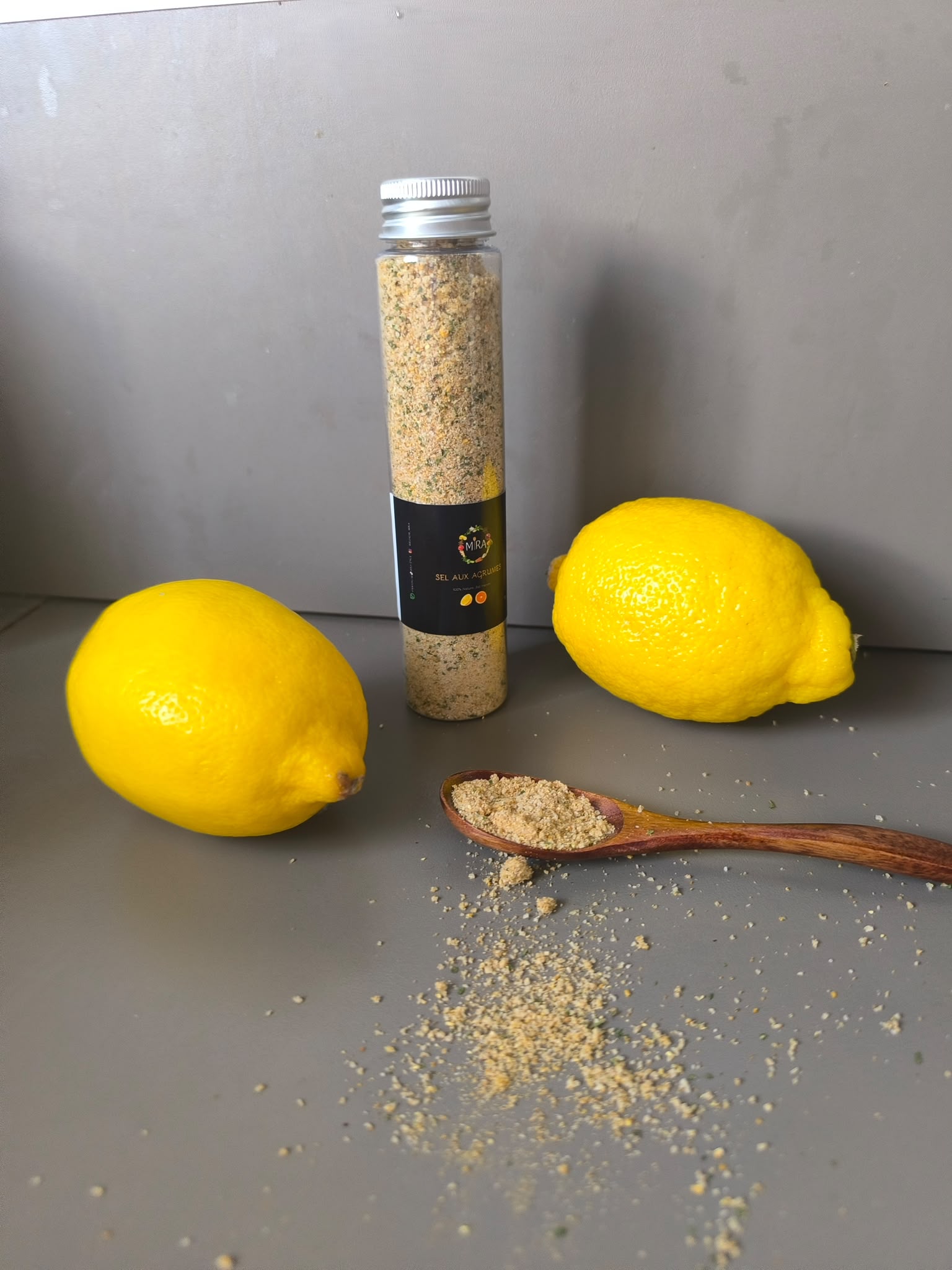 Le sel aux agrumes MIRA, entouré de citrons.